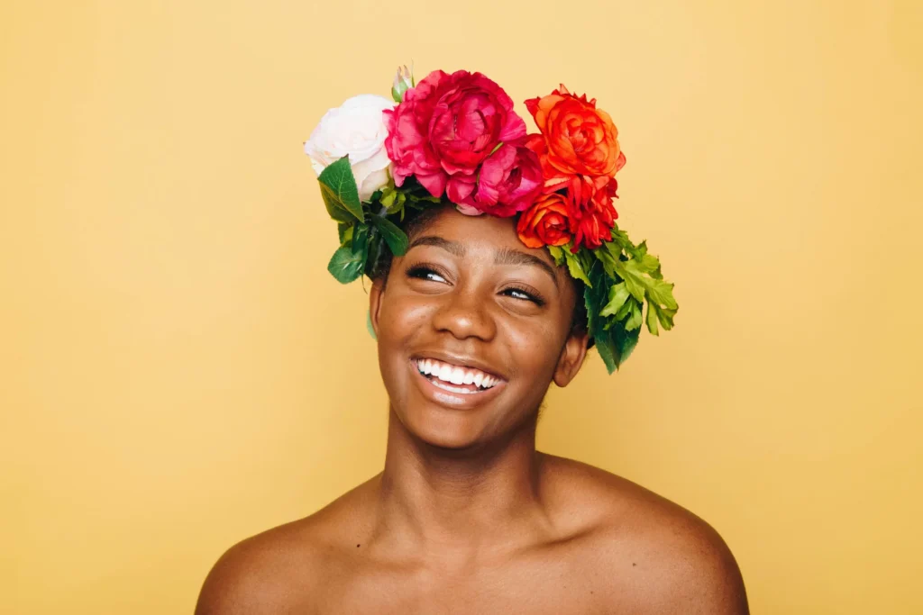 Lächelnde Person mit Blumenkranz