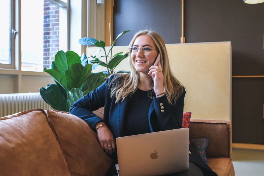 Frau mit Laptop telefoniert im Büro